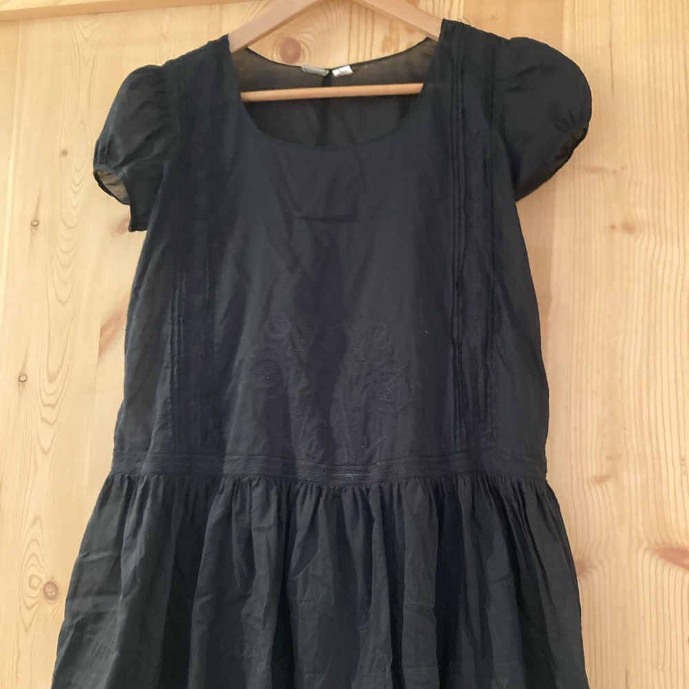 A beautifully detailed black cover up, dress or top.